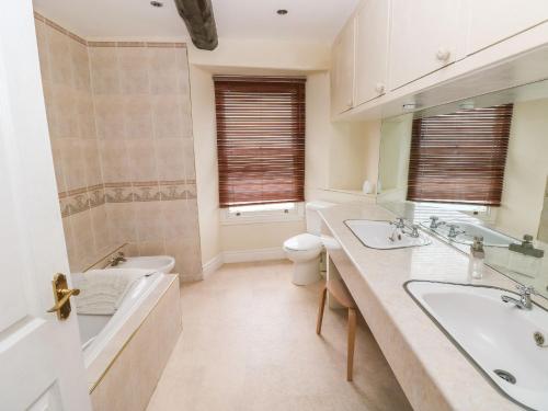 a bathroom with two sinks and a tub and a toilet at Gower View in Tenby