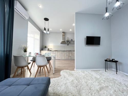ein Wohnzimmer mit einem blauen Sofa und einer Küche in der Unterkunft LUX в новом ЖК in Pawlodar