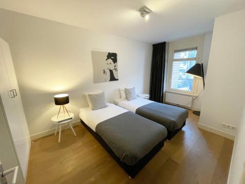 Un dormitorio con 2 camas y una silla. en Residences Jordan Canal, en Ámsterdam