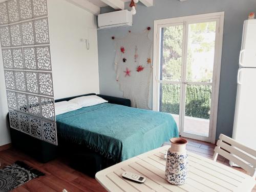 a bedroom with a bed and a table and a window at Da Carmen e Peppe in Santa Flavia