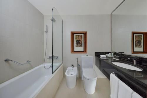 a bathroom with a toilet and a sink and a shower at Holiday Inn Tabuk by IHG in Tabuk