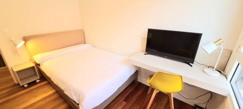 a small room with a bed and a desk with a television at PISO EN DURANGO in Durango