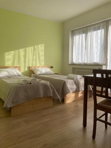 um quarto com 2 camas, uma cadeira e uma janela em Lavini em Marco