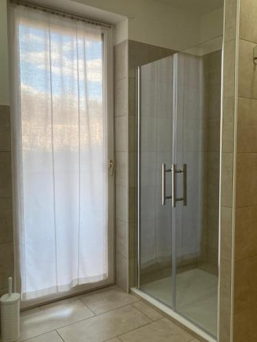 une douche avec une porte vitrée dans une salle de bain dans l'établissement Lavini, à Marco