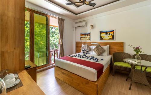 1 dormitorio con 1 cama, mesa y sillas en Ocean Lilly Inn, en Hangnaameedhoo
