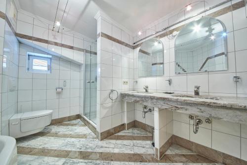 y baño con lavabo, ducha y aseo. en Marys Holiday Penthouse, en Saalbach Hinterglemm