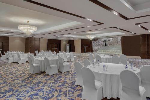 a banquet hall with white tables and white chairs at Holiday Inn Tabuk by IHG in Tabuk