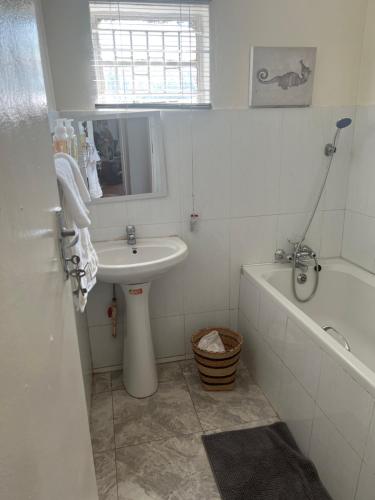uma casa de banho com um lavatório, uma banheira, um lavatório e um WC. em Mukala Lodge em Lusaka