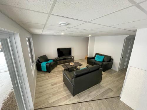 a living room with two couches and a tv at Chalets domaine Otis in Saint-Félix-d'Otis