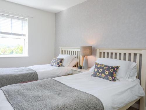a bedroom with two beds and a window at Bryntirion in Moelfre