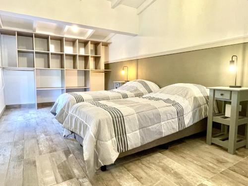 1 dormitorio con 2 camas y mesa. en Cabaña con spa Vida Abundante en Villa Yacanto