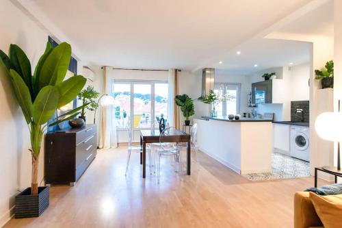 un salon avec une table et une cuisine dans l'établissement C5 - 2 BDR Blvd Carnot - 10 min Palais - AC & Terrace Sea View, à Cannes