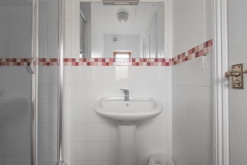 ein weißes Bad mit einem Waschbecken und einer Dusche in der Unterkunft Blacklaines Annexe in Gloucester