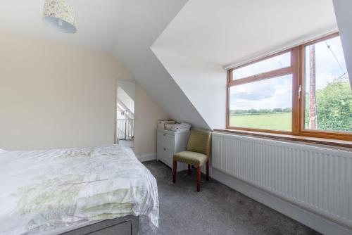 a bedroom with a bed and a chair and a window at Blacklaines Annexe in Gloucester