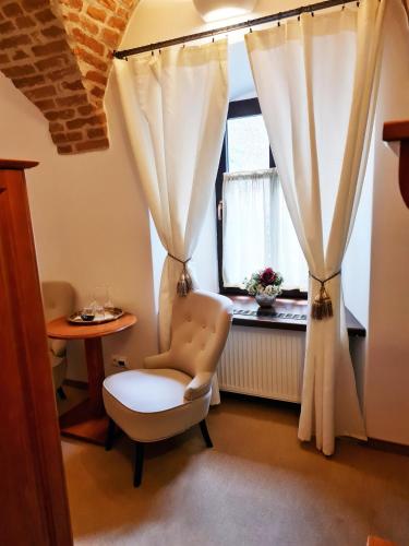 a living room with a chair and a window at Penzión pod kláštorom in Pezinok