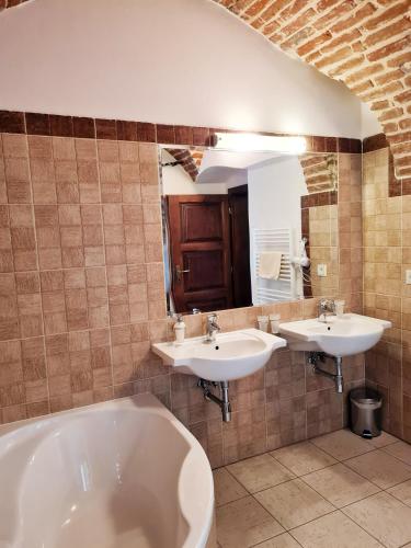 a bathroom with two sinks and a tub at Penzión pod kláštorom in Pezinok