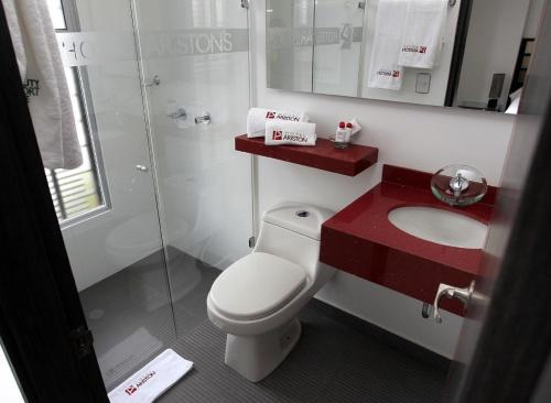 a bathroom with a white toilet and a sink at AW Hotel Ariston in Bogotá