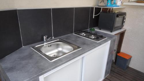 Il comprend une cuisine équipée d'un évier et d'une cuisinière. dans l'établissement Suite Harlequin, à Cournonterral