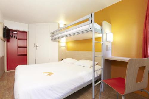 Première Classe Montélimar Nord في Les Tourrettes: غرفة نوم مع سرير بطابقين وكرسي احمر
