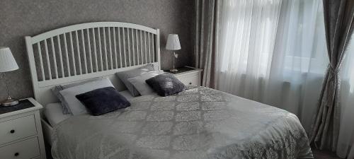 a bedroom with a white bed with pillows and a window at Villa Shafaly in Mariánské Lázně