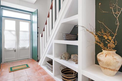 a staircase with white shelves and a vase at Casa da Praia in Alcochete