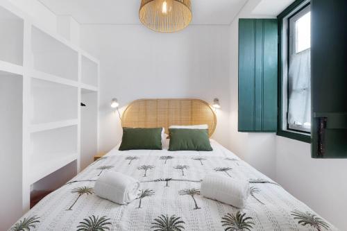 a bedroom with a large bed with green pillows at Casa da Praia in Alcochete