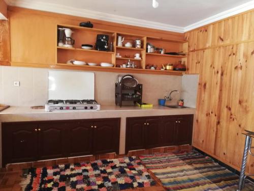 uma cozinha com armários de madeira e um fogão em Gite Oukaimeden em Oukaïmeden