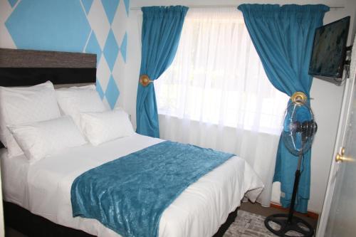 - une chambre avec un lit et une fenêtre avec des rideaux bleus dans l'établissement Adorable Private Room in Germiston, à Germiston