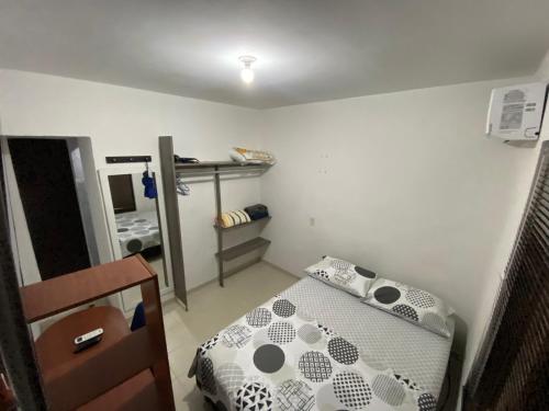 um pequeno quarto com uma cama e um espelho em Apartaestudio amoblado - Pasoancho/Sur-Centro/Cali em Cali