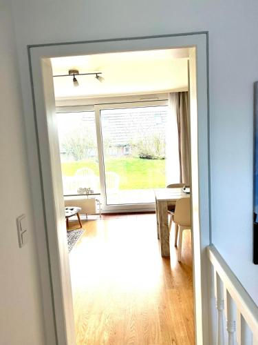 a door leading to a living room with a large window at Calma 1 ebenerdig in Wenningstedt