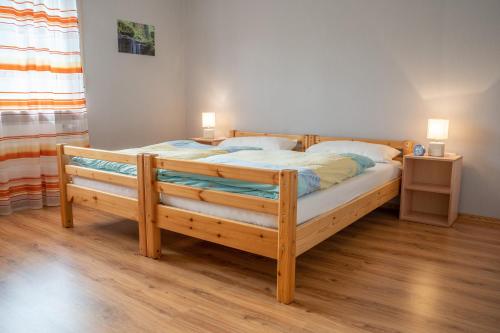 1 dormitorio con 1 cama de madera y 2 almohadas en Ferienwohnung Brunnenplatz, 