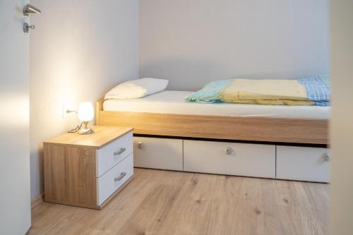 Habitación pequeña con cama y mesita de noche en Ferienwohnung Brunnenplatz, 