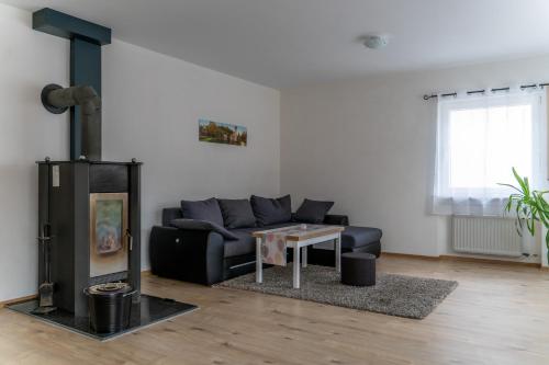 sala de estar con sofá y estufa de leña en Ferienwohnung Brunnenplatz, 