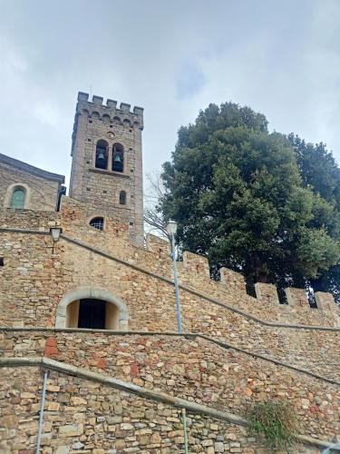 un grande muro di mattoni con una torre sopra di La Fontanella a Castagneto Carducci