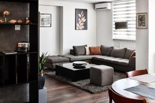 a living room with a couch and a table at 2 bedroom Penthouse in city center, free parking in Sarajevo