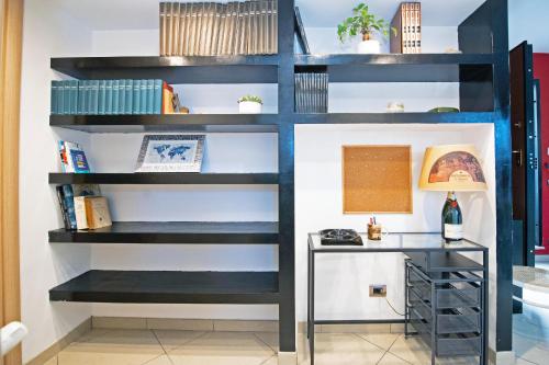 a book shelf in a room with a desk at B&Bea sweet home Aurelia in Rome