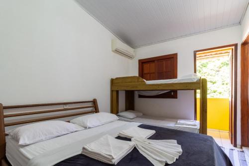 Duas camas num quarto com um beliche em Pousada Flor do Dendê em Arraial d'Ajuda