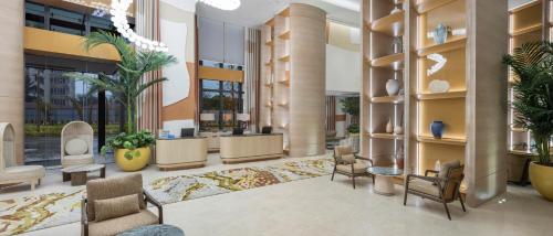 a lobby of a building with chairs and plants at Hyatt Regency Izmir IstinyePark in Izmir