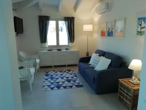 ein Wohnzimmer mit einem blauen Sofa und einem Tisch in der Unterkunft Villa Agata in Budoni