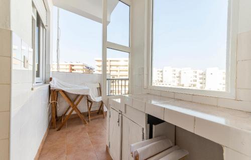 a white bathroom with a window and a table at Abrotea Apartments in Lagos