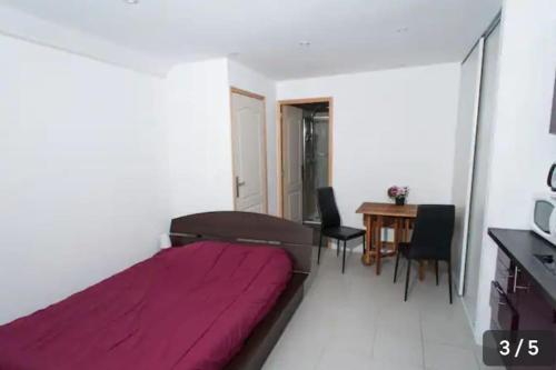 a bedroom with a bed and a table and chairs at STUDIO MEUBLE PROCHE NANCY in Marbache