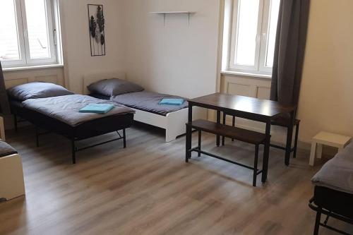 a room with two beds and a table and a desk at Monteurwohnung - Vaihingen in Vaihingen an der Enz
