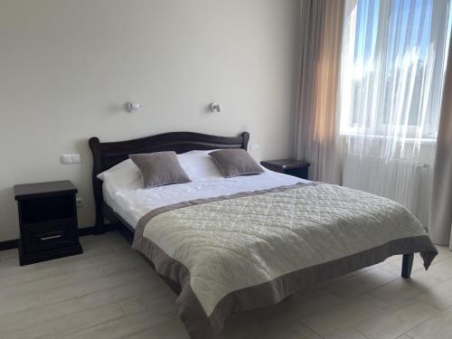 a bedroom with a bed and a window at Sun Lidia in Chernivtsi