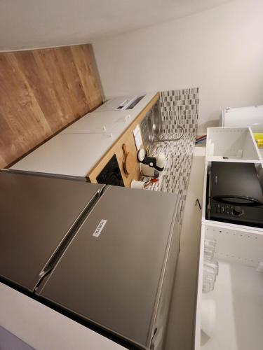 Il comprend une petite cuisine équipée d'un réfrigérateur et d'une cuisinière. dans l'établissement Studio cozy centre ville rdc, à Bar-le-Duc