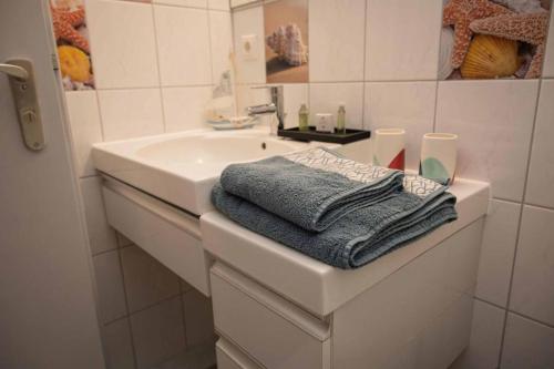 a white bathroom with a sink and a towel at Ferienwohnung Winklworld inklusive aktivCARD in Sankt Englmar