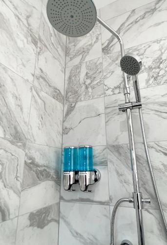 a shower with a shower head in a bathroom at 1 Bed / 1 Sofa Bed 'Scandi' Style Ground Floor Apartment in Yeovil