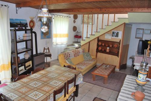 a living room with a table and a couch and stairs at B&B Baddesalighes in Bolotana
