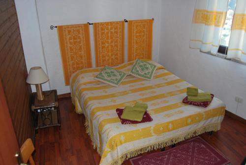 a bedroom with a bed with green and yellow sheets at B&B Baddesalighes in Bolotana