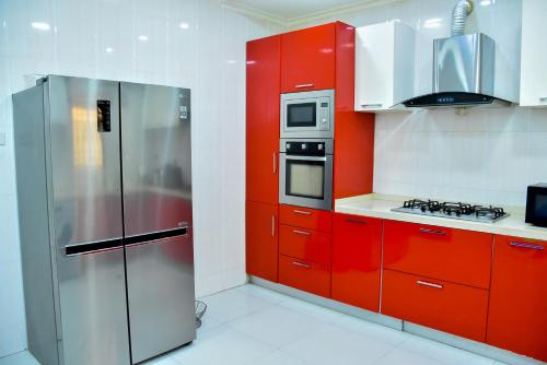 a kitchen with red cabinets and a stainless steel refrigerator at Beautiful Town House in Lagos