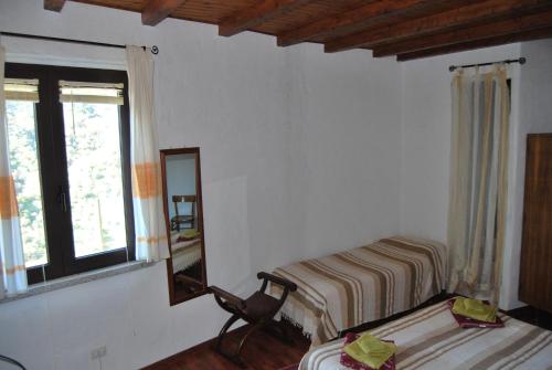 a bedroom with two beds and a mirror and a chair at B&B Baddesalighes in Bolotana